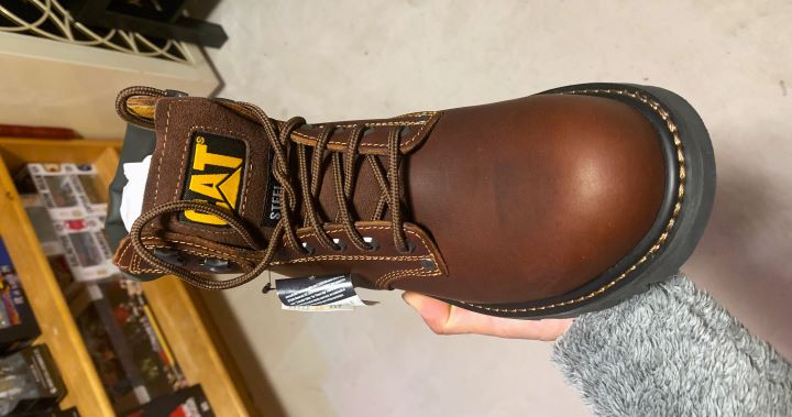 Holding Second Shift Steel Toe Work Boot from the brand Cat Footwear